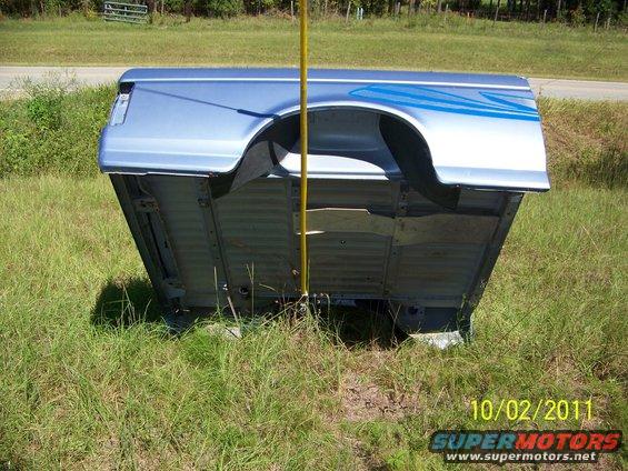 Blue pickup truck bed with graphic stripes, seen outdoors
