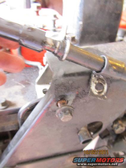 Close-up of a metal bracket with a bolt and a tube attached