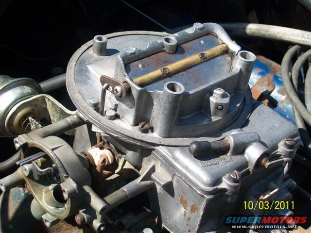 Close-up of a carburetor with visible date stamp and website