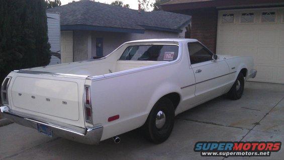 White Ford Ranchero parked in a driveway. Has a '10' sticker in the rear window