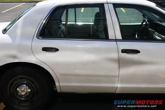 White 2003 Ford Crown Victoria sedan, side view, showing rear door and wheel