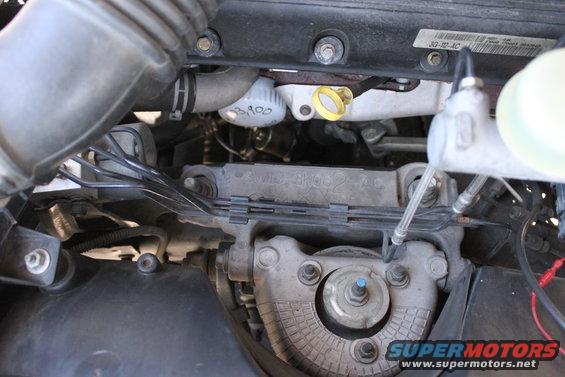 Engine bay with hoses, wires, and engine parts. Oil filter marked "3,100"