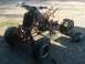 1995 Yamaha BANSHEE - An ATV is partially assembled outdoors on a gravel surface, with its engine and frame visible.