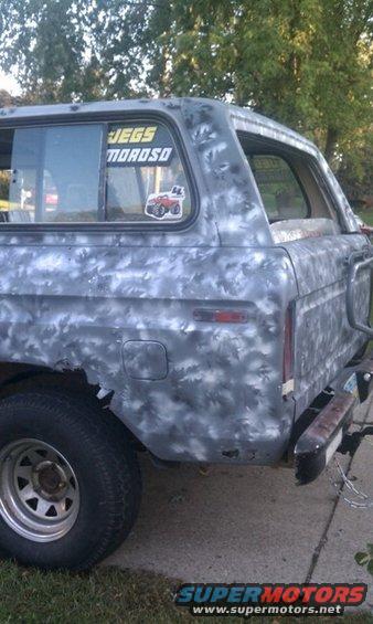 Gray 1978 Ford Bronco rear quarter panel with camouflage paint and a JEGS sticker on the window