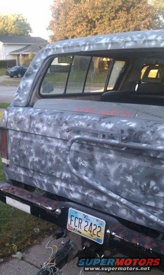 Rear view of a Ford Bronco with camouflage paint, showing license plate FCR 2422