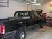 1992 Ford F-150 - A black 1992 Ford F-150 pickup truck is parked in a garage, with its hood up and a toolbox in the bed.