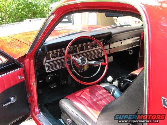 Red 1967 Ford Ranchero interior with a red steering wheel and two-tone seats