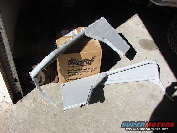 Two gray metal fender flare parts in front of Summit Racing box