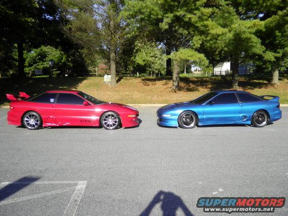 Red and blue 1995 Ford Probe cars parked facing each other on asphalt