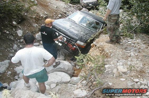 1993 Ford Bronco stuck in a rocky ditch, front 3/4 view