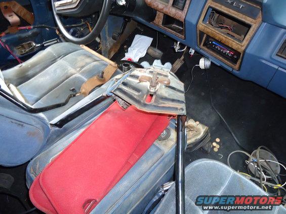 Interior of a 1985 Ford Bronco showing blue seats, dashboard, and floor