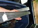 1985 Ford Bronco - Stack of metal trim pieces being held, likely for a vehicle restoration project.