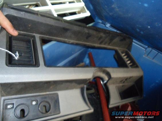 Dashboard trim piece with air vents and ignition key slots. A red tube is visible behind it
