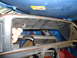 1985 Ford Bronco - A close-up view of a vehicle's dashboard cavity, revealing internal components and a hand interacting with the space.