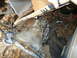 1985 Ford Bronco - A vehicle part, likely from a transmission, is shown in a cluttered environment with debris.
