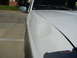 1996 Ford Bronco - A white SUV's fender shows damage, with a circular stain and scuff marks visible.