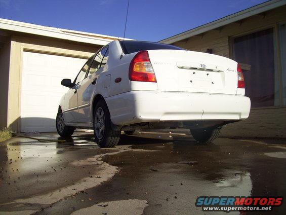 Rear view of a white sedan parked in a driveway