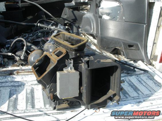 HVAC assembly and black plastic interior trim parts in a truck bed