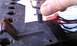 1990 Ford Bronco - A hand uses a socket wrench to secure a part during a wiper repair.