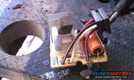 Close-up of a circuit board with wires and a capacitor, likely a wiper motor control module
