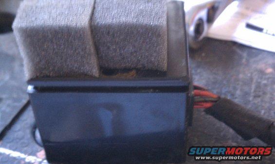 Black wiper motor housing with foam padding and exposed red and black wires