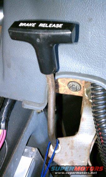 Brake release lever with white text 'BRAKE RELEASE' on black handle