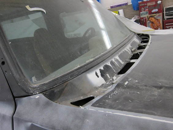 Truck windshield and cowl area, appears to be undergoing bodywork. Interior visible through windshield