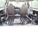 1996 Ford Bronco - The interior of a vehicle shows exposed metal flooring and two front seats.