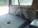 1996 Ford Bronco - The rear cargo area of a vehicle, showing the carpeted floor and interior paneling.