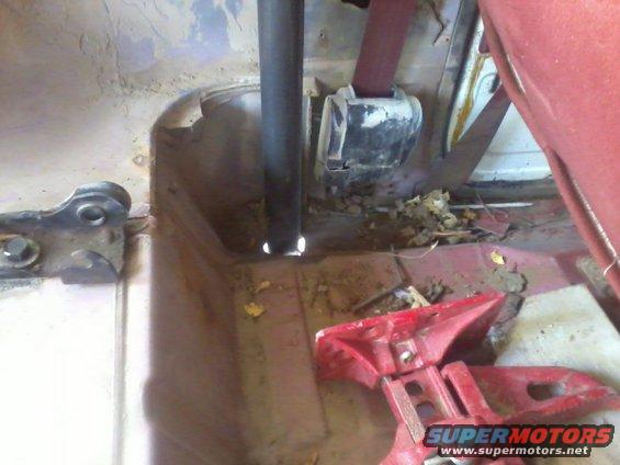 Interior view of a vehicle showing a seatbelt and a metal pole