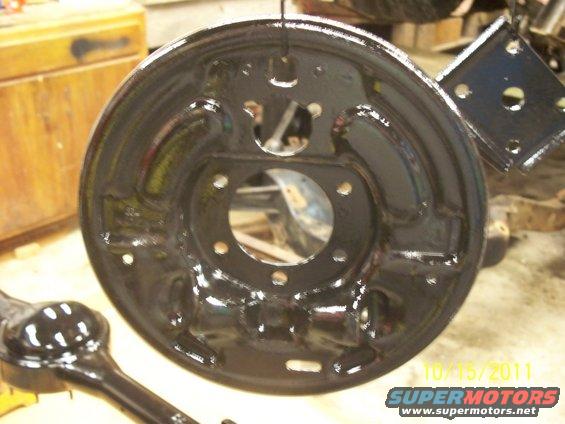 black brake backing plate and part of an axle housing