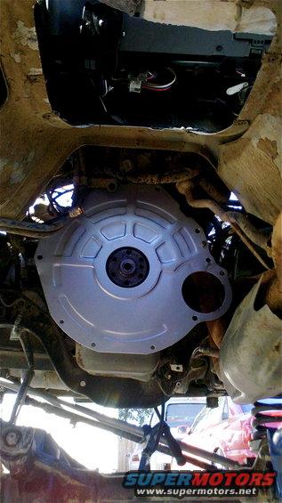 Underside view of a transmission bell housing with some wiring above it