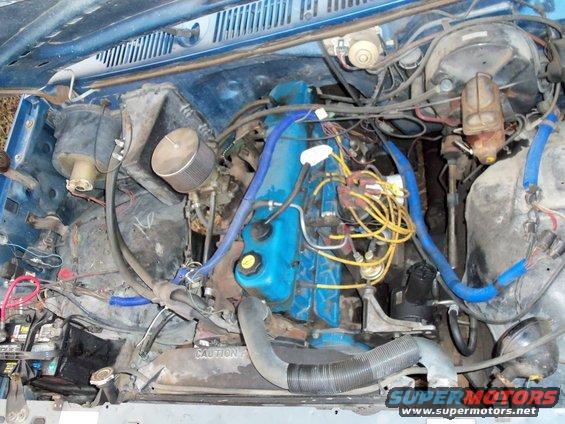Engine bay with blue valve covers, yellow spark plug wires, and an air filter