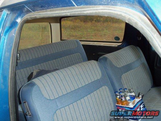 Blue SUV interior with striped seats and a cooler of drinks on the seat