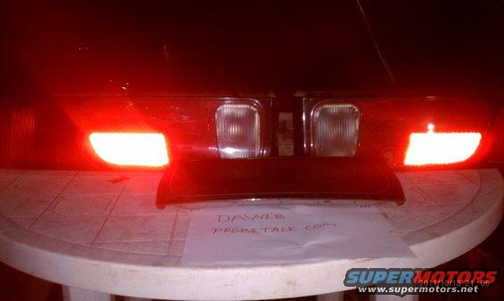 Car taillights with red brake lights illuminated, resting on a table