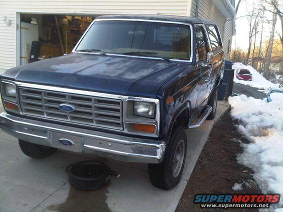 1985 Ford Bronco parked in driveway with oil drain pan underneath