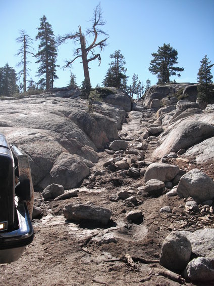 Black 1991 Ford Bronco front fender and bumper on a rocky, dirt trail