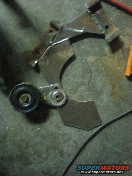 Metal bracket with pulley, possibly for a vehicle engine