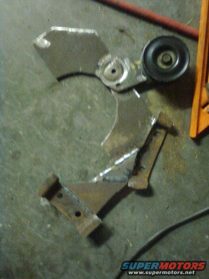 Scattered metal pieces, one with a pulley wheel, on a concrete floor