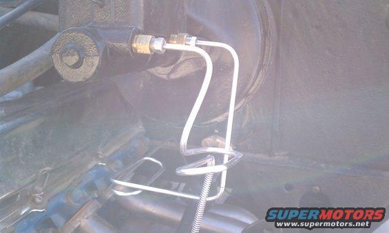 Brake master cylinder with metal lines and coiled spring support