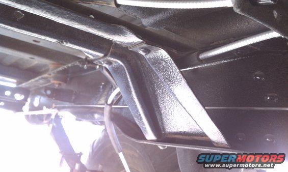 Undercarriage of a vehicle with black painted frame components and silver brake lines