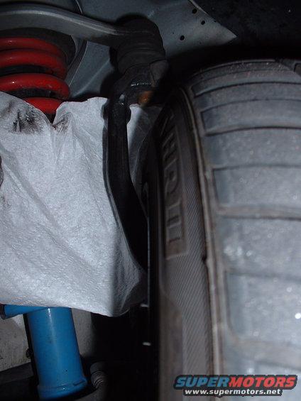 Car suspension with red coil spring, blue shock absorber, and tire