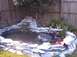 1990 Ford Bronco - A backyard pond features a rock waterfall and surrounding greenery, with a watermark visible.