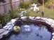 1990 Ford Bronco - A tranquil garden scene a pond with a fountain, surrounded by lush greenery and decorative elements.