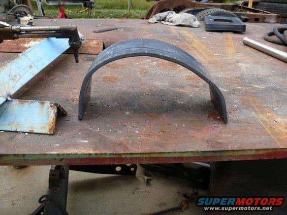 Metal fender flare on a rusty workbench with a cutting torch