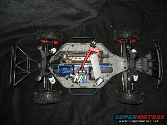 Remote control car chassis with exposed electronics, battery, and motor, viewed from above