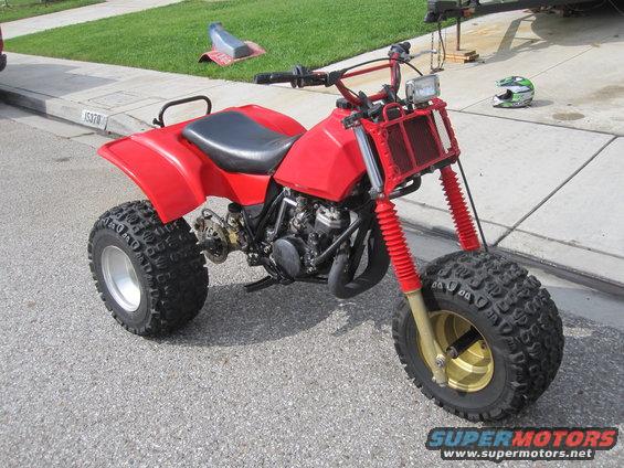 Red three-wheeled ATV with gold rims and red shocks