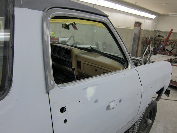 1987 Dodge 1500 interior showing dashboard, shifter, and door panel; exterior door is primed