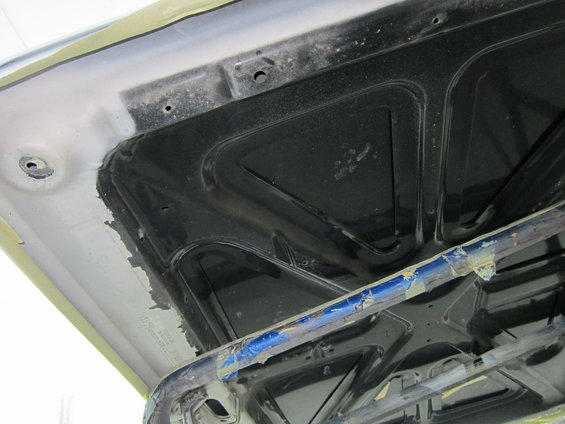 underside of a car hood, showing bracing and insulation material
