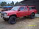 1991 Toyota Pickup/SR5 - This red Toyota pickup truck, likely a 1991 model, is equipped with a camper shell and roof rack.